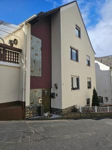 a white and red building with a door at Blick auf den Rhein in Kestert