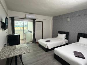 a hotel room with two beds and a glass table at The Bless Residence in Hat Yai +24 photos
