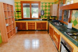 a kitchen with wooden cabinets and green and yellow at Cortijo Cristea in Cehegín