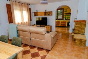 a living room with a couch and a television at Cortijo Cristea in Cehegín