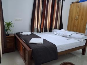 a bedroom with a bed with two towels on it at Eleeza Homestay in Cochin