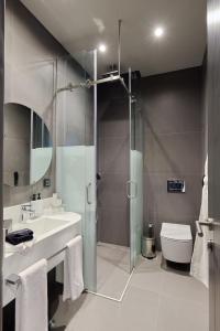 a bathroom with a shower and a sink and a toilet at Bomonti Suites Istanbul in Istanbul +65 photos