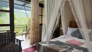 a bedroom with a canopy bed and a balcony at Forest Rawana homestay Ella in Ella