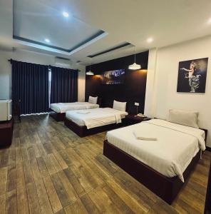 a hotel room with two beds and a television at KN Guesthosue in Phumĭ Réach Born (1)
