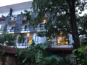 an exterior view of a white building with balconies at KN Guesthosue in Phumĭ Réach Born (1)