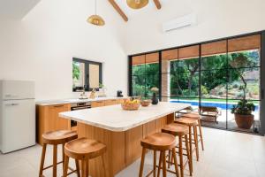 a kitchen with a large island with bar stools at Three Little Birds in Vrbanj