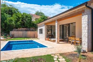a backyard with a swimming pool and a house at Three Little Birds in Vrbanj