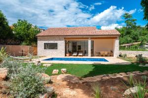 a house with a swimming pool in a yard at Three Little Birds in Vrbanj