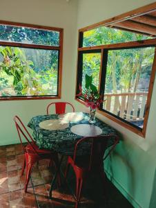 a table and chairs in a room with two windows at Beautiful cabin on Easter Island in Hanga Roa