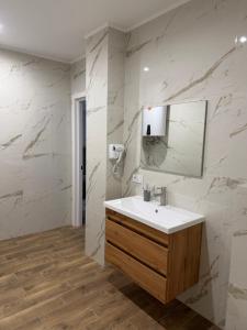 a bathroom with a sink and a mirror at Карпати Кайзервальд апарт in Karpaty +51 photos
