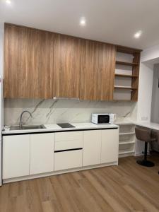 a kitchen with white counters and wooden cabinets at Карпати Кайзервальд апарт in Karpaty