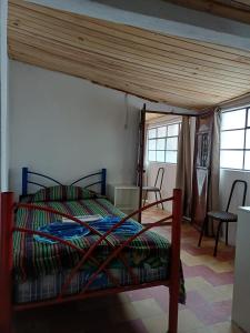 a bedroom with a bed in a room with windows at Hotel casa de doña Rome in Chichicastenango