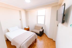 ein kleines Schlafzimmer mit einem Bett und einem Stuhl in der Unterkunft HsDverdi in Santa María