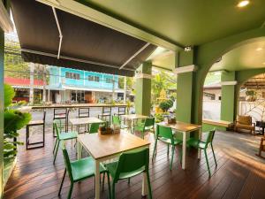 a restaurant with tables and chairs and a bar at Karon Living Room - SHA Plus in Karon Beach