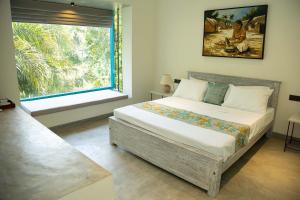 a bedroom with a large bed and a window at KAHA by TONIK, Talpe - Pool & Garden in Talpe