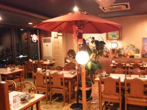 尾道市にある尾道ビュウホテルセイザンのテーブルと大きな赤い傘を備えたレストラン
