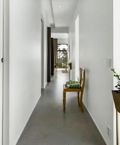 a hallway with a chair and white walls at Architect Villa By Cliff Bathing In High Coast in Härnösand