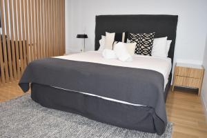 a bedroom with a large bed with a black headboard at Kove Apartment - G05 in Kiama