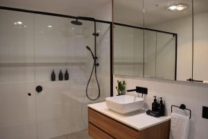 a bathroom with a sink and a shower at Kove Apartment - G05 in Kiama