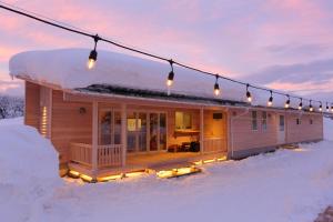 a house in the snow with lights on it at yamagata glam in Murayama
