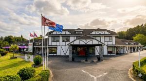 a building with two flags in front of it at Chelmswood Motel Taupo in Taupo