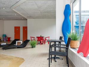 a room with red chairs and a blue vase on the wall at Søndervig Holiday Center in Ringkøbing