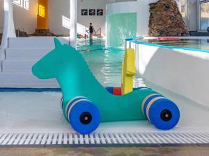 a green toy horse in a swimming pool at Søndervig Holiday Center in Ringkøbing