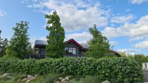 a house with a hedge in front of a house at Glampingtält in Österbybruk