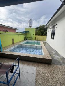 a swimming pool on the side of a building at Homestay Abah in Bidur