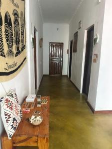 a room with a wooden table and a floor with water at Kipe House Nungwi in Nungwi