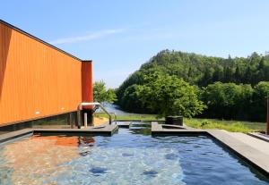 a swimming pool with a view of a river at yamagata glam in Murayama