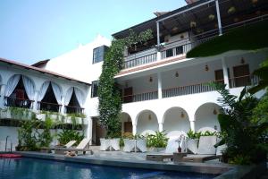 a hotel with a swimming pool in front of a building at Bougainvillea in Nagaon