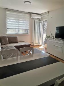 a living room with a couch and a tv at MDM Apartman Vrnjačka Banja in Vrnjačka Banja