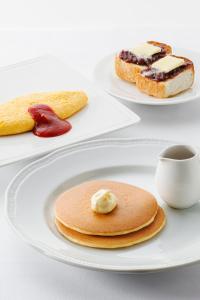 two plates with pancakes on them and a cup of coffee at Richmond Hotel Nagoya Nayabashi in Nagoya