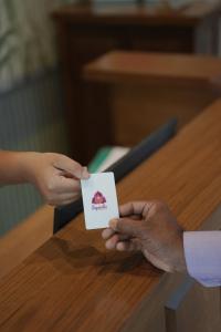 a person holding up a card at a table at Bougainvillea in Nagaon +142 photos