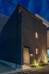 a black building with a door on the side of it at Hotel Arina HakataTaihaku in Fukuoka