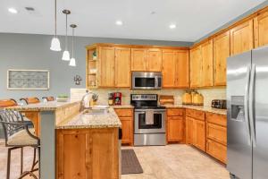 a kitchen with wooden cabinets and stainless steel appliances at Cliffside Paradise Waterfront in New Braunfels