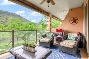 a screened in porch with two chairs and a table at Cliffside Paradise Waterfront in New Braunfels