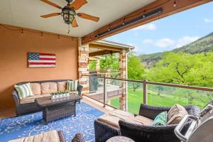 a porch with a couch and chairs on a balcony at Cliffside Paradise Waterfront in New Braunfels +32 photos