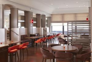 a restaurant with tables and chairs in a room at Hyatt Regency Bishkek in Bishkek