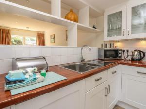 a kitchen with white cabinets and a sink at Delaware M2 in Yarmouth