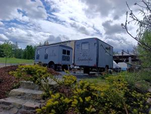 a truck with a trailer parked in a field at Andělka maringotka in Humpolec +7 photos