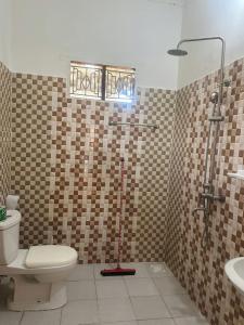 a bathroom with a toilet and a shower and a sink at Kipe House Nungwi in Nungwi +32 photos