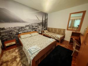 a bedroom with a bed and a painting on the wall at Apartman Jadran Private Parking in Dobrota
