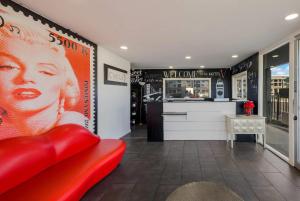 a red chair in a room with a counter at Rodeway Inn South San Francisco Airport in South San Francisco