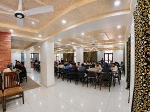 a group of people sitting at tables in a room at Lidder view resort in Muski
