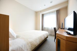 a hotel room with a bed and a flat screen tv at JR-East Hotel Mets Kitakami in Kitakami +27 photos