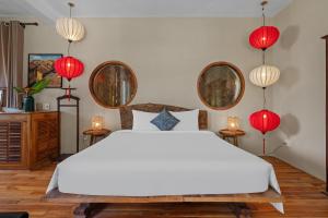 a bedroom with a large white bed with red lanterns at Lea's Garden in An Bàn (2)