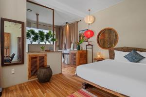 a bedroom with a white bed and a kitchen at Lea's Garden in An Bàn (2)