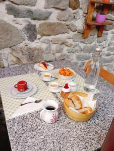 a table with a breakfast of coffee and bread at B&B Daddanca in Ales